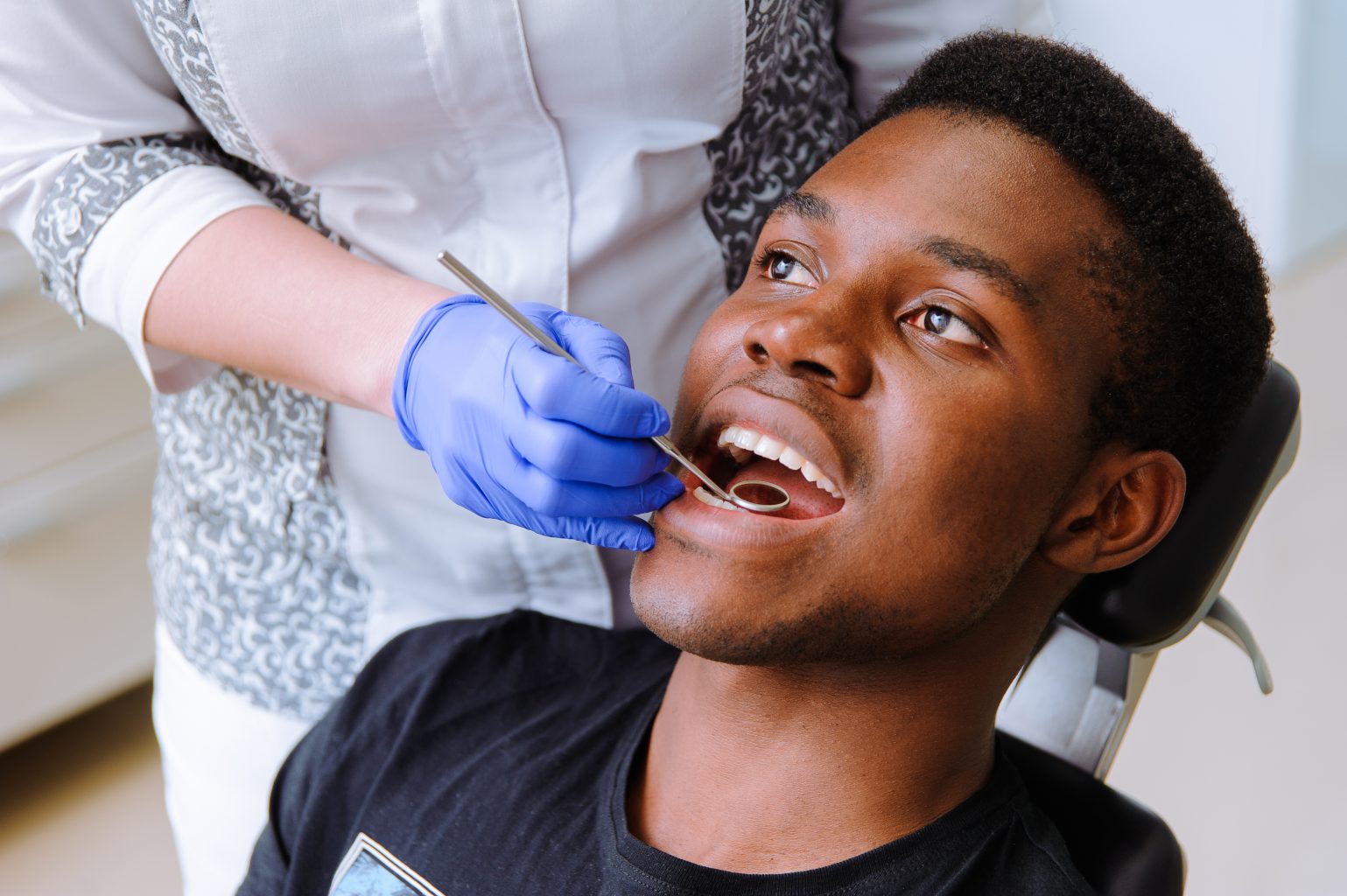 African Male Patient Getting Dental Treatment In Dental Clinic